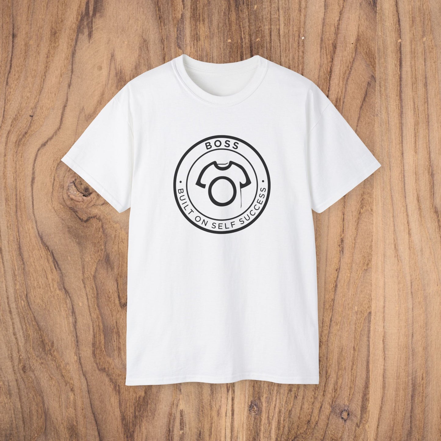 White t-shirt with a black logo on a wooden surface