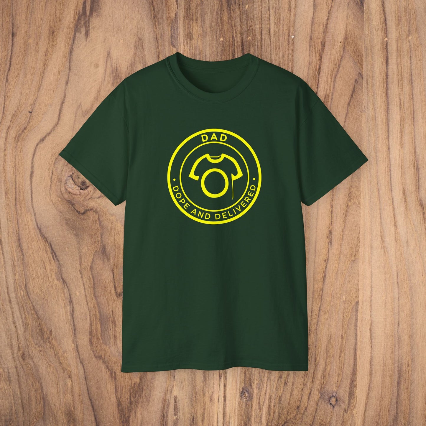 Green t-shirt with yellow graphic and text on a wooden surface